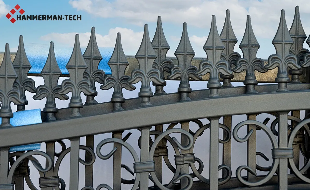 Nahaufnahme eines dekorativen Metallzauns mit Spitzen und geschwungenen Ornamenten vor blauem Himmel