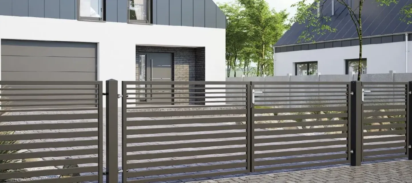 Modernes Grundstückszaun aus horizontalen Metallprofilen vor einem Einfamilienhaus